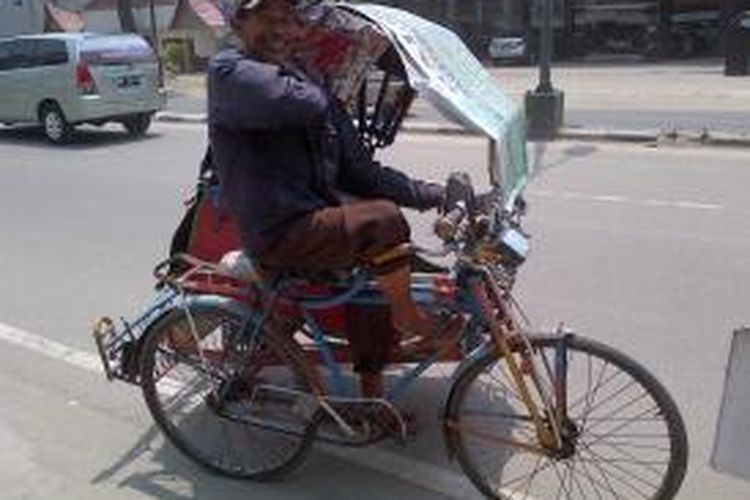Hasanauddin, 80, tampak letih usai menurunkan penumpang yang naik becak dayung tua miliknya. DESI