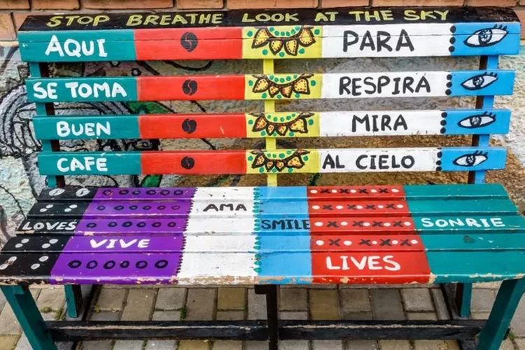 Sebuah bangku di Bogota, Kolombia, bertuliskan pesan-pesan berbahasa Spanyol dan Inggris, mengundang orang-orang yang lewat untuk rehat sambil meminum kopi.
