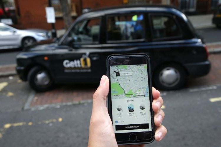 Seorang wanita memegang sebuah smartphone yang menunjukkan aplikasi layanan taksi ride-sharing Uber di London pada 22 September 2017. Pada hari itu otoritas transportasi London mengumumkan bahwa mereka tidak akan memperbarui lisensi Uber untuk beroperasi di kota tersebut saat lisensi berakhir pada 30 September untuk alasan keamanan. Uber mendapat kesempatan selama tiga minggu untuk mengajukan banding.