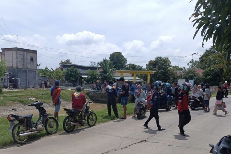 Warga saat berkumpul melihat penemuan mayat laki-laki mengambang di saluran irigasi Desa Cilandak Lor, Kecamatan Anjatan, Kabupaten Indramayu, Jawa Barat, Senin (15/12/2025)