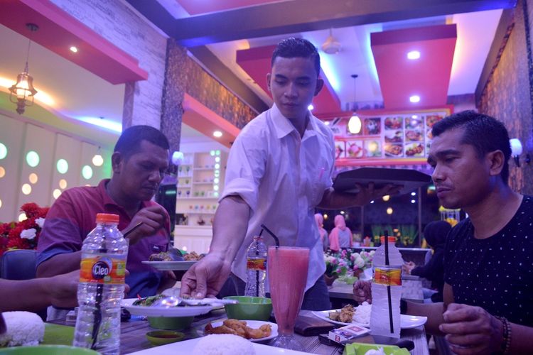 Pelayan menyajikan makanan dan minuman di Kafe Keysa, Langsa, Aceh, Jumat (10/3/2017) malam