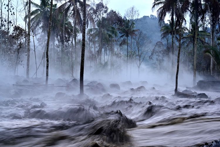 Kepulan asap menyelimuti area yang terendam banjir lahar hujan Gunung Semeru di Dusun Kamar Kajang, Candipuro, Lumajang, Jawa Timur, Kamis (16/12/2021). Erupsi Gunung Semeru pada Kamis pukul 09.01 WIB yang disusul hujan deras di daerah itu mengakibatkan banjir lahar hujan menerjang beberapa tempat di wilayah hilir.