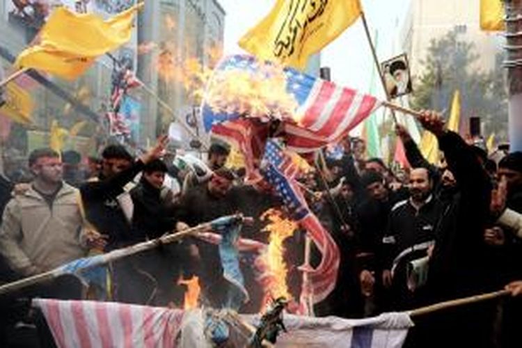 Ribuan warga Iran membakar bendera Amerika Serikat di Teheran, Senin (4/11/2013), dalam peringatan pengepungan kedubes AS 1979.