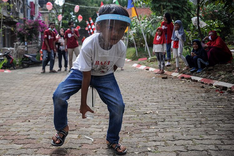 Foto dirilis Senin (14/9/2020), memperlihatkan seorang anak bertanding membawa pensil yang telah dimasukan ke dalam botol dalam rangka 17 Agustusan di Komplek Grand Cinunuk, Kabupaten Bandung, Jawa Barat. Dengan tetap menerapkan protokol kesehatan, pandemi Covid-19 nyatanya tak mengurangi semangat warga untuk merayakan HUT Kemerdekaan Ke-75 RI dengan caranya masing-masing.