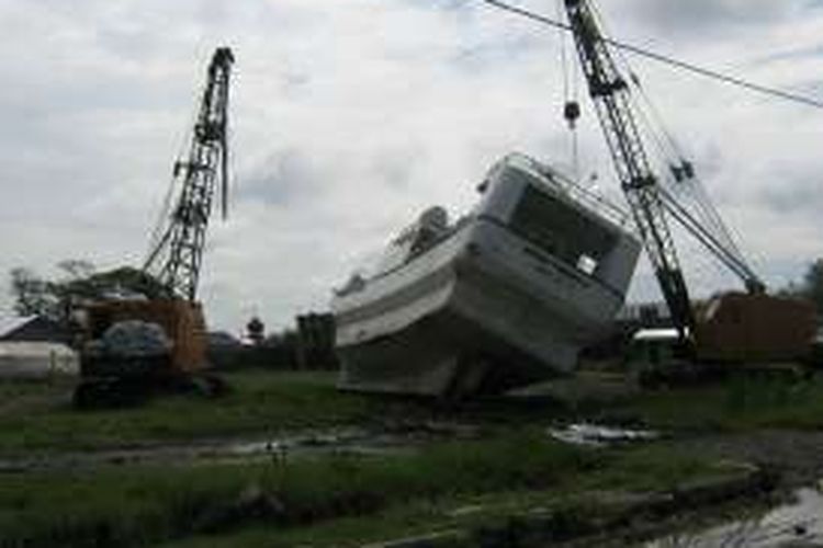Sebuah kapal terdampar di lapangan yang jauh dari laut setelah tersapu tsunami Aceh, 26 Desember 2004 silam. Foto diambil setahun setelah kejadian.