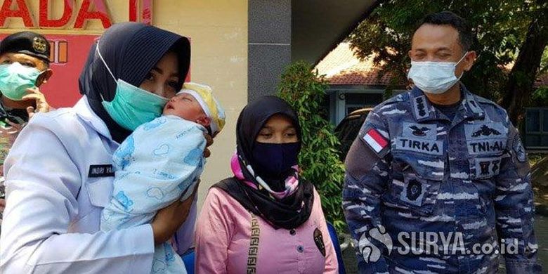 Bidan yang bertugas di Kantor Diskea Koarmada II, Indriyani menggendong bayi laki-laki yang berhasil ditolong dalam persalinan sungsang penuh risiko, Jumat (13/11/2020). 
