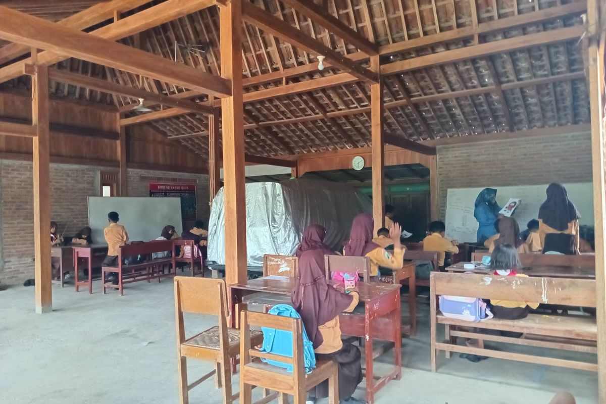BELAJAR DI TERAS RUMAH-- Ratusan siswa Sekolah Dasar Negeri (SDN) Gandong 3, Kecamatan Beringin, Kabupaten Ngawi, Jawa Timur terpaksa belajar di teras rumah warga sejak tiga bulan terakhir. Hal itu terjadi lantaran gedung sekolah yang rusak sementara diperbaiki.