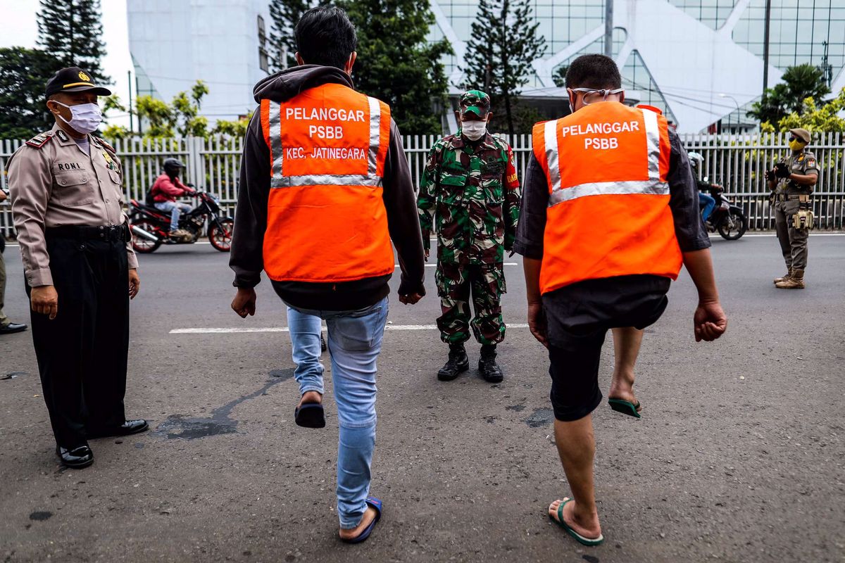 Petugas gabungan menghukum warga yang tidak menggunakan masker dengan melakukan baris berbaris saat patroli penegakan aturan pembatasan sosial berskala besar (PSBB) di Jl. Matraman Raya, Kecamatan Jatinegara, Jakarta Timur, Selasa (19/5/2020). Dalam kegiatan patroli PSBB tersebut, target penegakan untuk masyarakat yang tidak mengunakan masker dijalanan.