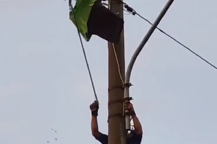 Anggota Damkar Kabupaten Semarang mengevakuasi seragam kerja yang tersangkut di kabel.