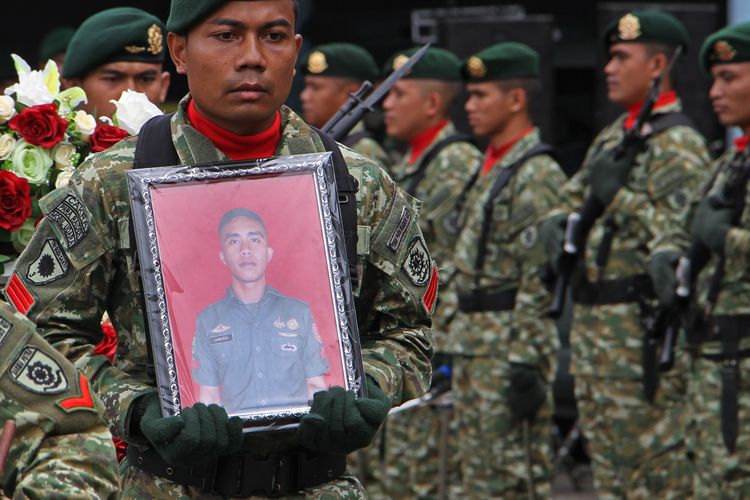 Anggota TNI membawa foto Praka Jumardi yang menjadi korban penembakan kelompok kriminal bersenjata (KKB) saat jenazahnya tiba di Bandara Internasional Sultan Hasanuddin, Kabupaten Maros, Sulawesi Selatan, Sabtu (4/3/2023). Praka Jumardi yang merupakan anggota Satgas Yonif Raider 303/SSM/13/1 Kostrad gugur saat melakukan evakuasi warga sipil yang ditembak oleh KKB di Distrik Yugumuak, Papua Tengah pada Jumat (3/3/2023) dan jenazahnya akan dimakamkan di Kabupaten Bone, Sulawesi selatan. 