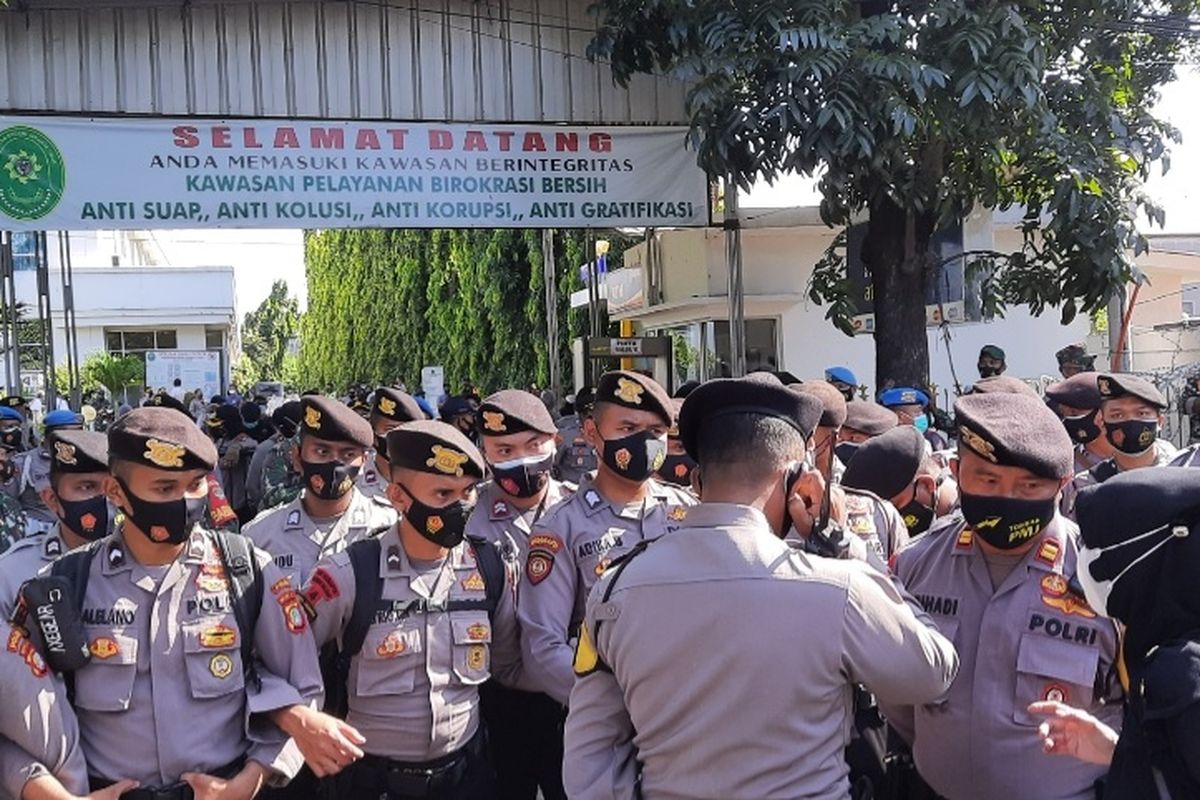 Ratusan polisi berjaga ketat di depan pintu gerbang Pengadilan Negeri (PN) Jakarta Timur pada hari ini, Jumat (26/3/2021), menjelang sidang tatap muka Rizieq Shihab.