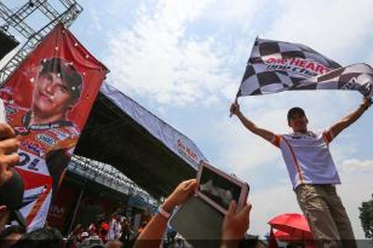 Pebalap Repsol Honda, Marc Marquez, membawa bendera finis saat kunjungan ke Sirkuit Sentul, Bogor, Jawa Barat, Selasa (21/10/2014).