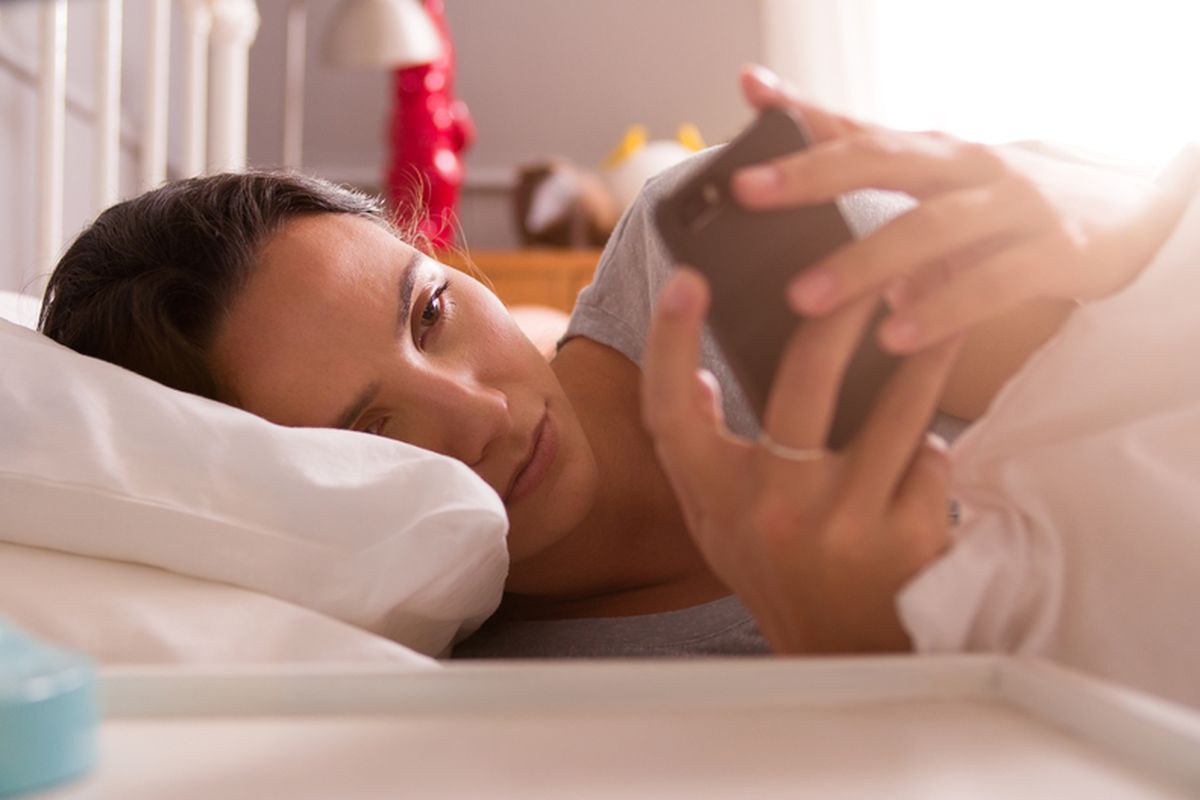 Ilustrasi bangun tidur mengecek ponsel.
