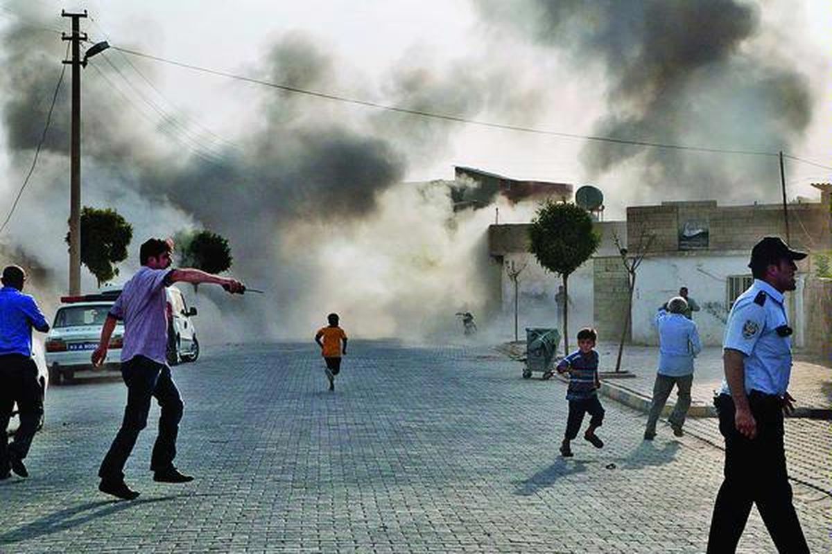Beberapa warga Turki berlarian dan  asap mengepul dari tempat ledakan setelah Suriah melakukan serangan ke kota Akcakale, Turki. Serangan yang merusak sejumlah bangunan di Turki itu menewaskan sedikitnya lima orang, Rabu (3/10). Sejumlah warga Turki yang lain cedera akibat serangan dari kota perbatasan Tall al-Abyad di Suriah itu. 