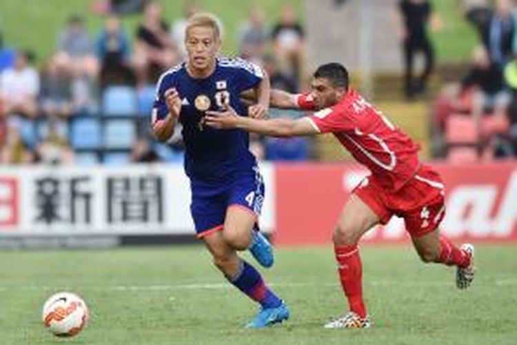 Pemain Jepang, Keisuke Honda (kiri), dilanggar pemain Palestina, Ahmed Mahajna, dalam pertandingan Grup D Piala Asia 2015 di Newcastle, Senin (12/1/2015).