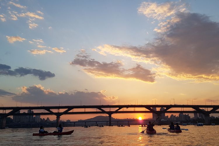 Suasana kayaking di Sungai Han saat matahari terbenam.