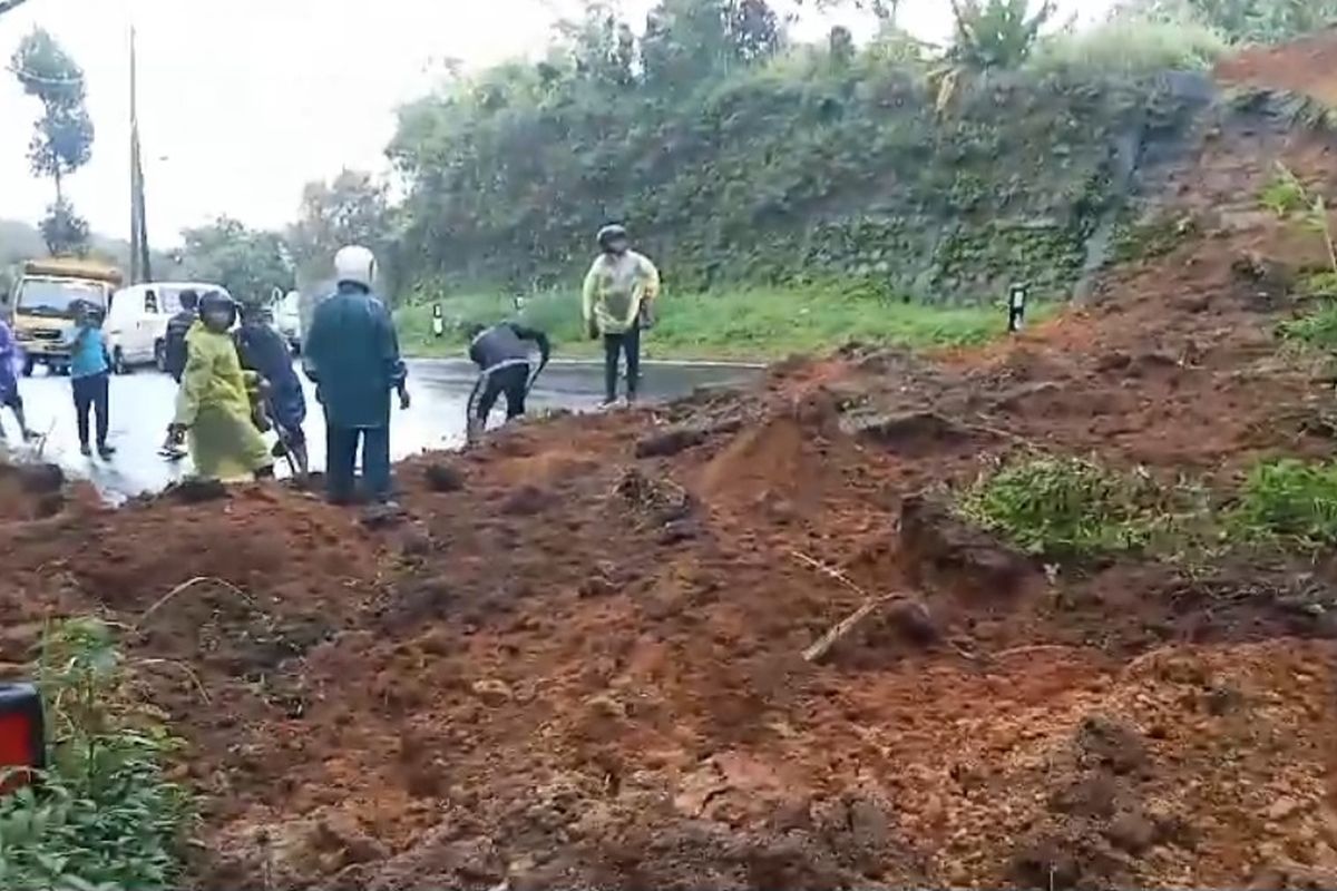 Petugas dan warga membersihkan material tanah longsor di jalur Singaraja-Denpasar di Desa Gitgit, Kecamatan Sukasada, Kabupaten Buleleng, Provinsi Bali, Senin (20/1/2025). 