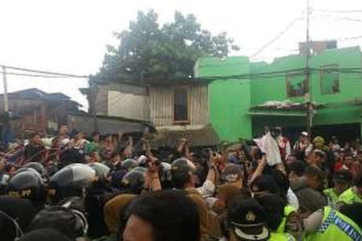 Suasana keributan yang terjadi antara warga dan aparat pemerintahan menjelang penertiban kawasan Pasar Ikan, Penjaringan, Jakarta Utara, Senin (11/4/2016).