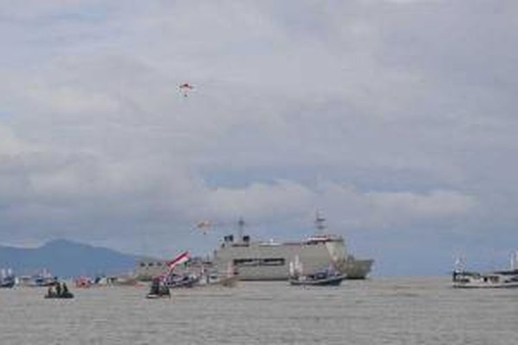 Parade kapal perang RI (KRI), kapal nelayan dan helikopter melintas di Pantai Talise, Palu, Sulawesi Tengah, Minggu (15/12/2013), dalam rangkaian Hari Nusantara 2013.