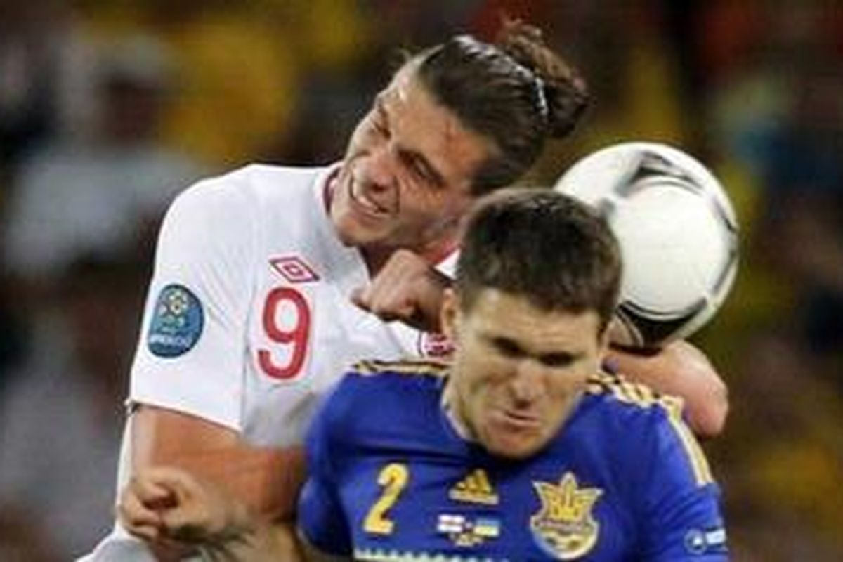 Penyerang tim nasional Inggris, Andy Carroll (kanan) berduel di udara dengan pemain Ukraina, Yevhen Selin, dalam laga penyisihan Grup D Piala Eropa 2012 di Donbass Arena di Donetsk, Selasa (19/6/2012).