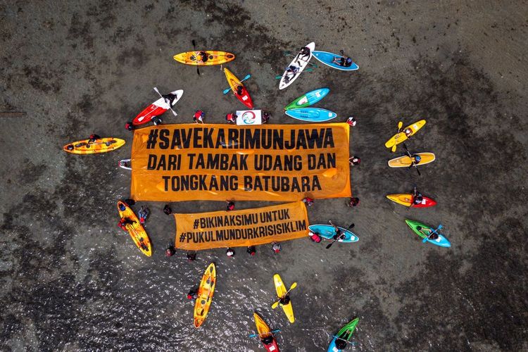 Rombongan warga Karimunjawa dan komunitas lingkungan membentangkan spanduk di area kerusakan laut akibat aktivitas tambak di Karimunjawa, Selasa (19/9/2023).