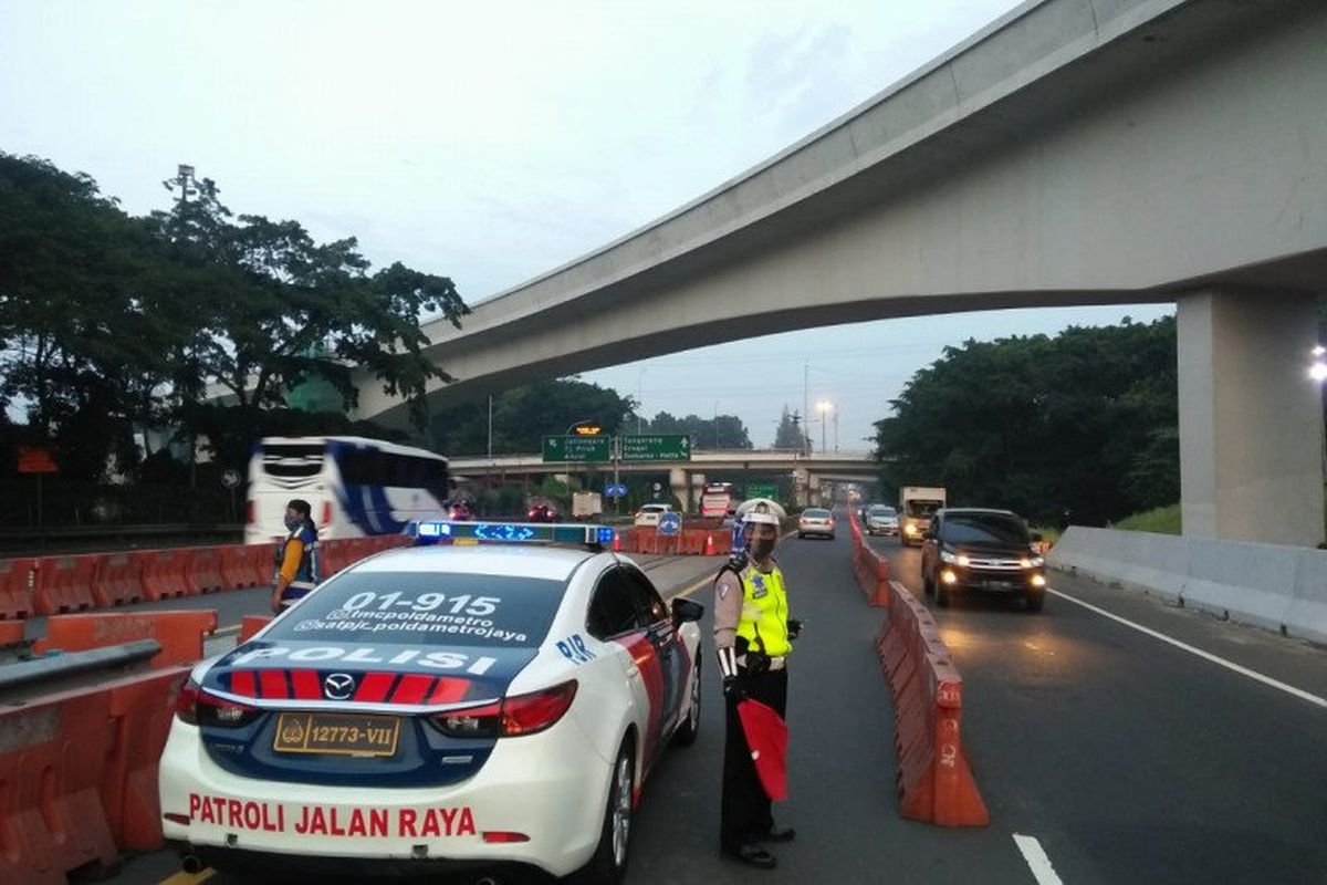 Petugas kepolisian mengatur lalu lintas di sekitar kawasan Halim yang mengarah ke lintasan Tol Dalam Kota Jakarta, Selasa (9/6/2020). Petugas menerapkan rekayasa lawan arah dalam rangka mengurangi potensi kepadatan kendaraan di sekitar Simpang Susun Cawang. 