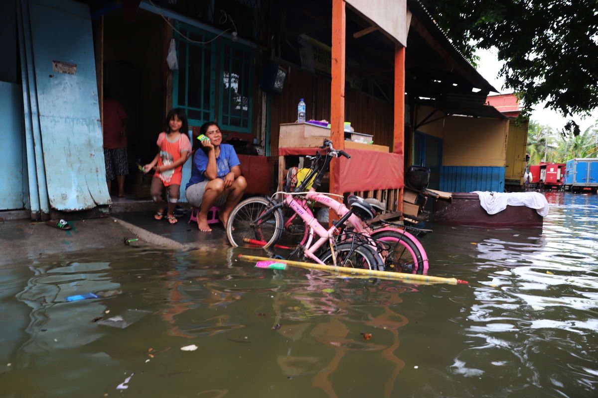 Warga tetap beraktivitas meski rumah mereka terendam banjir di wilayah Teluk Gong, Penjaringan, Jakarta Utara, Sabtu (4/1/2020).Hujan lebat di awal tahun membuat kawasan teluk gong masih terendam banjir.