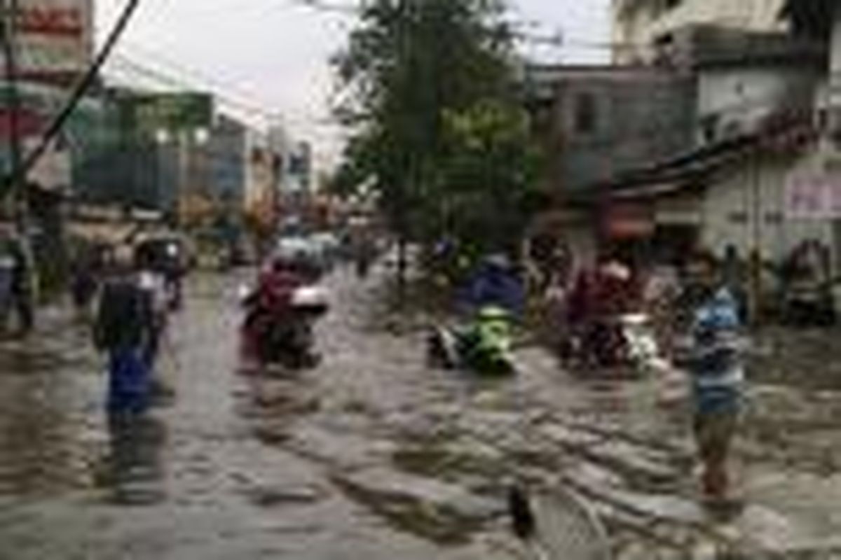 Hujan deras menyebabkan banjir di kawasan Kemandoran dan Palmerah, Senin (7/7/2014).
