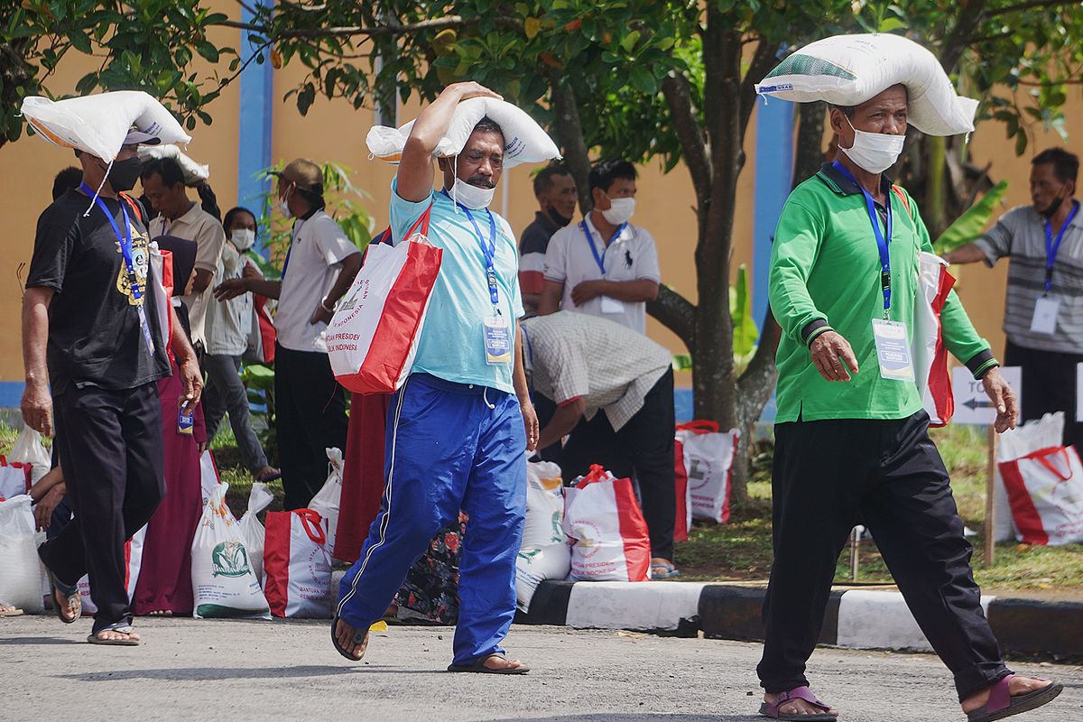 Warga penerima bantuan beras dan sembako membawa paket bantuan yang dibagikan di Gudang Bulog, Klahang, Sokaraja, Banyumas, Jawa Tengah, Rabu (3/1/2024).  