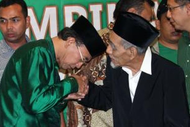 Ketua Partai Persatuan Pembangunan Suryadharma Ali (kiri) mencium tangan Ketua Majelis Syariah KH Maimun Zubair (kanan) usai melakukan konferensi pers di Kantor DPP PPP, Jakarta, Selasa (22/4/2014). Dalam pertemuan tersebut Majelis Syariah PPP menyatakan agar dua kubu yang berseteru di PPP menempuh jalan Islah.