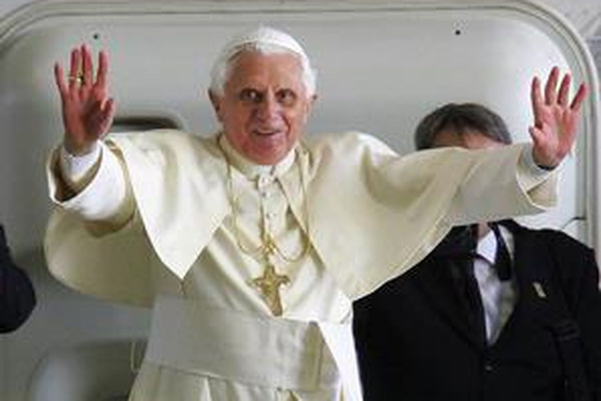 Paus Benediktus XVI melambaikan tangan di tangga pesawat sebelyum terbang kembali ke Roma, Senin (21/7).