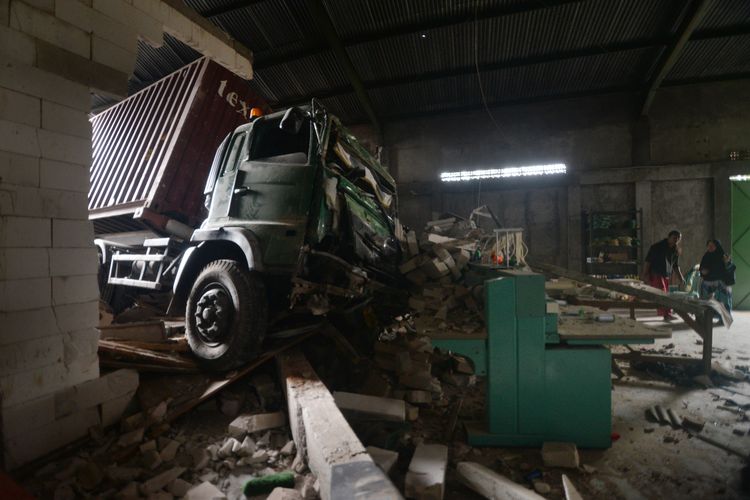 Warga berada di dekat truk kontainer yang mengalami kecelakaan tunggal menabrak bangunan di Jalan Solo-Semarang, Boyolali, Jawa Tengah, Kamis (12/12/2024). Kecelakaan tunggal truk kontainer bermuatan biji plastik itu menabrak bangunan gudang yang diduga truk mengalami masalah pada pengereman dan dalam peristiwa tersebut tidak ada korban jiwa. ANTARA FOTO/Aloysius Jarot Nugroho/foc.