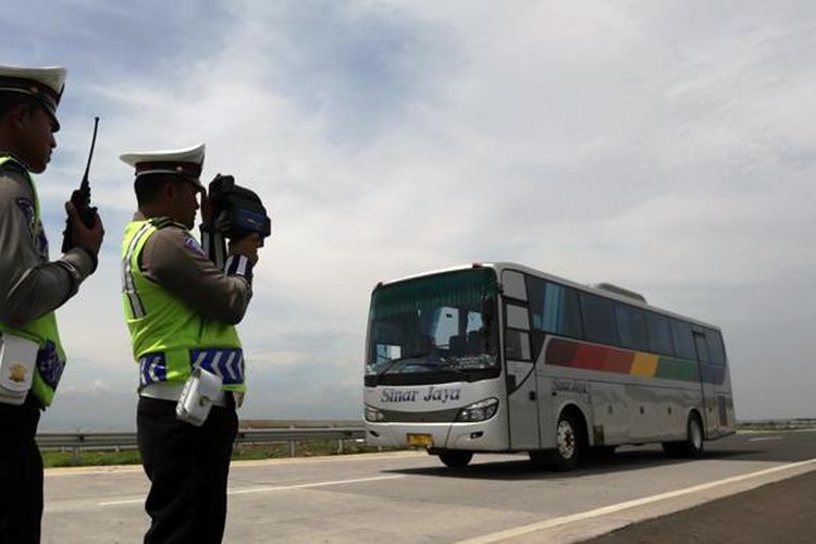 Petugas dari Kepolisian Daerah Jawa Barat (Polda Jabar) menggunakan alat pendeteksi laju kendaraan (speed gun) di ruas tol Cikampek-Palimanan KM.165 arah Palimanan, di Majalengka, Senin (14/12). 