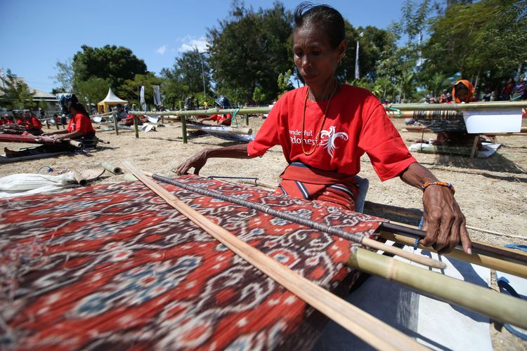 Penenun menenun bersama saat mengikuti Festival Sandalwood dan Expo Tenun Ikat di Waingapu, Sumba Timur, Kamis (11/07/2019).  Sedikitnya 200 orang penenun bersama-sama menenun untuk memeriahkan acara ini.