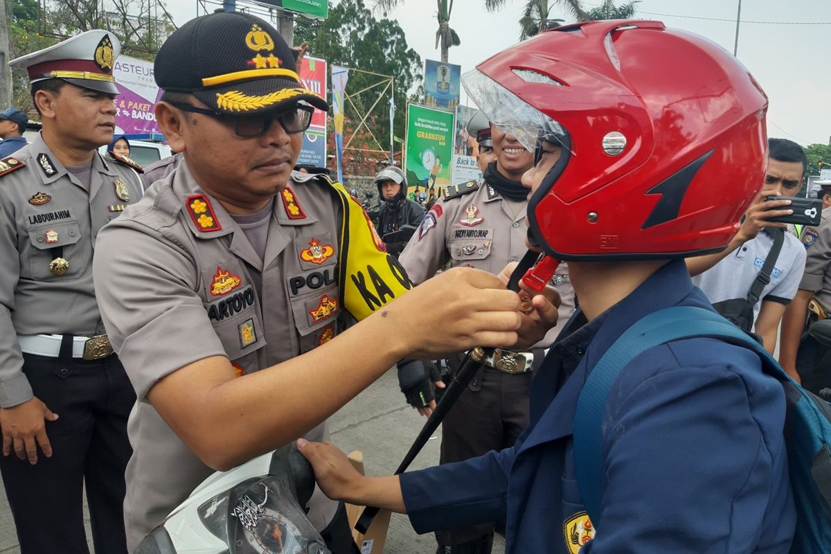 Polres Sumedang membagikan helm gratis kepada mahasiswa di depan kampus Unpad Jatinangor, Sumedang, Jawa Barat, Kamis (10/10/2019) siang. AAM AMINULLAH/KOMPAS.com