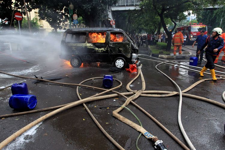 Petugas berusaha memadamkan mobil Daihatsu Zebra B2791AJ yang terbakar di Jalan Trunojoyo, samping Mabes Polri, Kebayoran Baru, Jakarta, Rabu (4/2/2015). Mobil itu membawa lima tangki berisi ratusan liter bahan bakar minyak.  KOMPAS IMAGES/KRISTIANTO PURNOMO