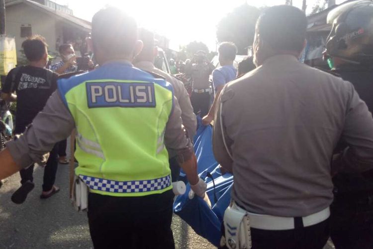 Polisi dari unit Laka Lantas Polres Pematangsiantar mengevakuasi pemotor tewas ditabrak truk yang jasadnya terhimpit kolong truk dari tempat kecelakaan lalu lintas di Jalan Pasar Batu, Kelurahan Siopat Suhu, Kecamatan Siantar Timur, Jumat (29/10/2021) sekitar pukul 15.30 WIB.