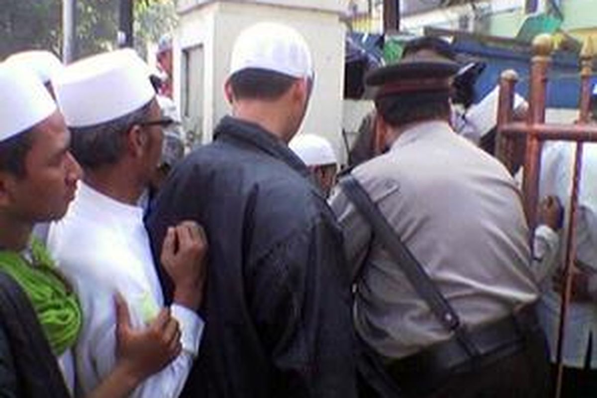 Ratusan pendukung FPI menjalani pemeriksaan polisi saat akan memasuki Pengadilan Negeri Jakarta Selatan. 