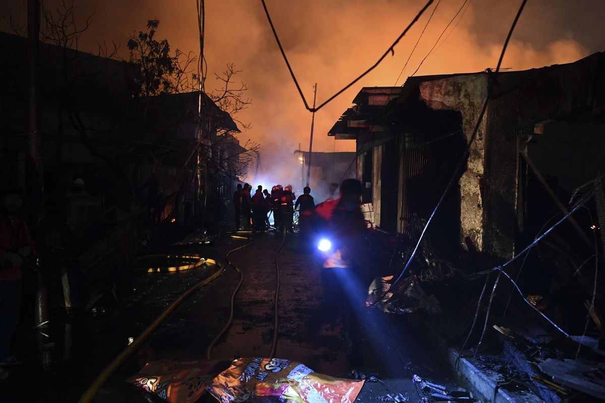 Sejumlah petugas berusaha memadamkan api yang membakar rumah warga imbas kebakaran Depo Pertamina Plumpang,kawasan Jalan Koramil, Rawa Badak Selatan, Koja, Jakarta Utara, Jumat (3/3/2023).