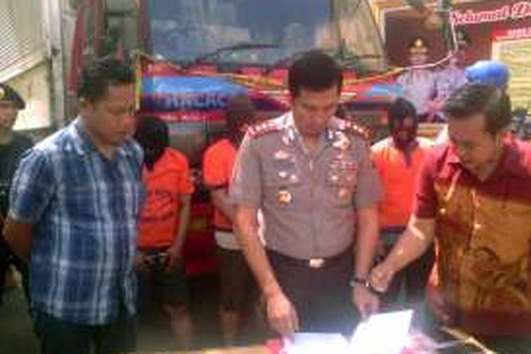 Kapolres Gresik AKBP Adex Yudiswan (tengah), saat melihat barang bukti kejahatan para tersangka penggelapan, Minggu (17/7/2016).