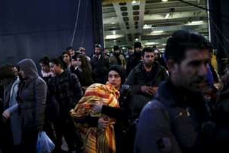 Para pengungsi dan migran menaiki kapal ferry Nissos Rodos di pelabuhan Piraeus, dekat Athena, Yunani, 13 Januari 2016.