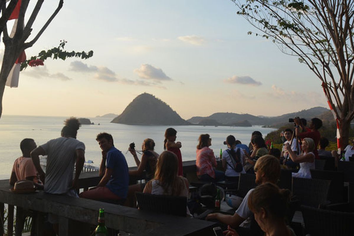 Turis asing sedang duduk di Restoran Paradise Labuan Bajo, Nusa Tenggara Timur, Minggu (27/8/2017) untuk menunggu matahari terbenam di ujung barat Pulau Flores. 