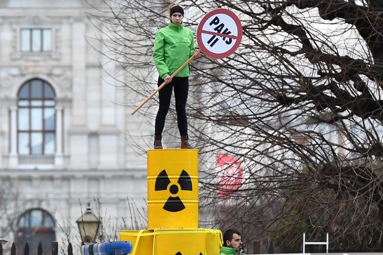 Petugas polisi menyaksikan pengunjuk rasa Greenpeace berdemonstrasi menentang perluasan pembangkit listrik tenaga nuklir Hungaria Paks selama kunjungan perdana menteri Hungaria Viktor Orban ke Kanselir Austria Sebastian Kurz di Wina pada 30 Januari 2018.
