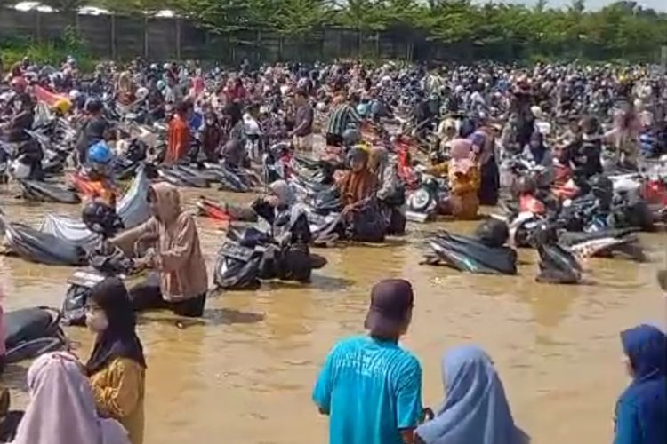 Pekerja pabrik sepatu dan sandal di Desa Sidaresmi, Kecamatan Pabedilan, Kabupaten Cirebon, Jawa Barat, berusaha menyelamatkan sepeda motor mereka dari kepungan banjir, Kamis (6/3/2024) siang.