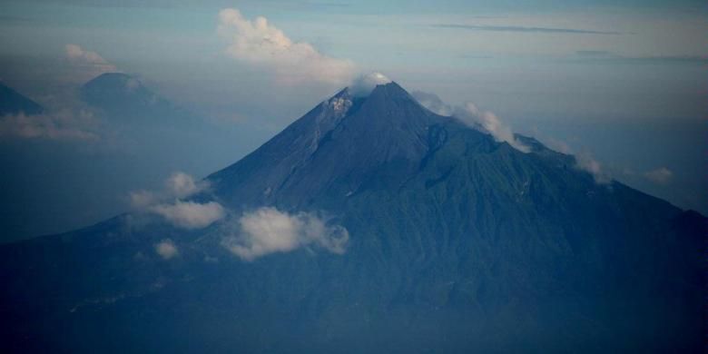 Puncak gunung berapi tipe Strato-volcano Merapi menjulang dengan ketinggian 2.978 meter di kawasan Provinsi DI Yogyakarta dan Jawa Tengah, Minggu (21/4/2013). Meskipun memiliki risiko bencana alam, jutaan warga terus bertahan bermukim di kaki gunung itu antara lain karena kesuburuan tanah vulkaniknya yang memungkinkan mereka hidup dengan bercocok tanam.