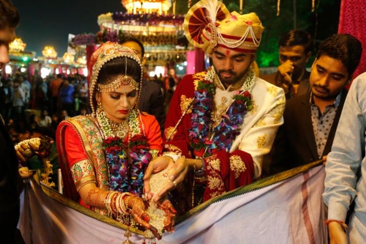 Sepasang pengantin melakukan ritual saat pernikahan massal di Surat, India, Minggu, 24 Desember 2017.