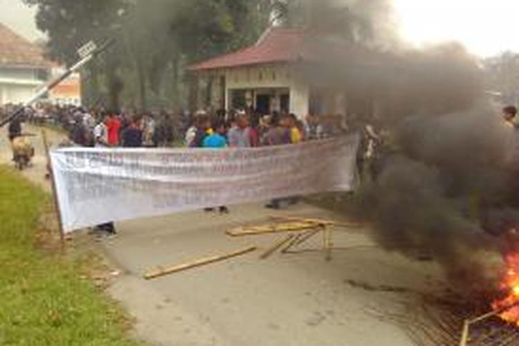 Para mahasiswa USI Pematangsiantar saat melakukan aksi bakar ban di dalam kampus mereka di Jalan Sisingamangaraja, Pematangsiantar, Sumatera Utara, Senin (12/10/2015).