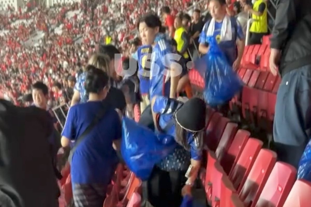 Supoter Jepang membersihkan sampah di Stadion Gelora Bung Karno usai laga, Jumat (15/11/2024)