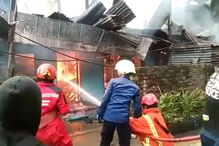 Dinas Pemadam Kebakaran Kota Makassar berusaha memadamkan api rumah yang dibakar pemiliknya di Jl Rappokalling, Makassar, Selasa (29/3/2022).
