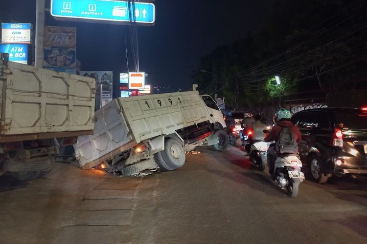 Penampakan truk bermuatan batu bata yang terperosok ke saluran air di Jalan Cirendeu, Ciputat Timur, Tangerang Selatan pada Selasa (3/10/2023).